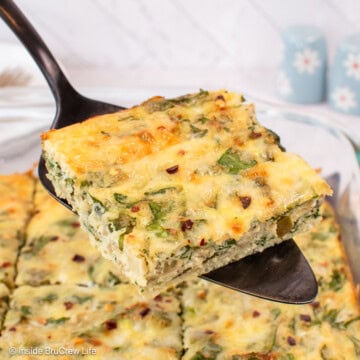 A spatula lifting a square of spinach egg bake out of a pan.