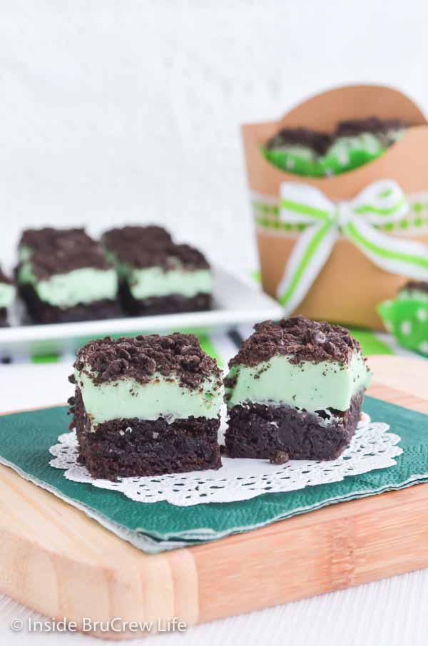Two brownies topped with mint fudge and thin mint cookie crumbles.