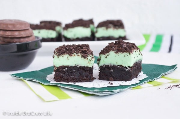 Two brownies topped with mint fudge and mint cookies.