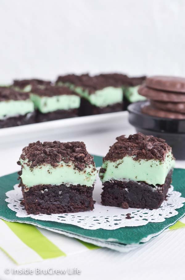Two brownies topped with mint fudge and thin mint cookie crumbles.