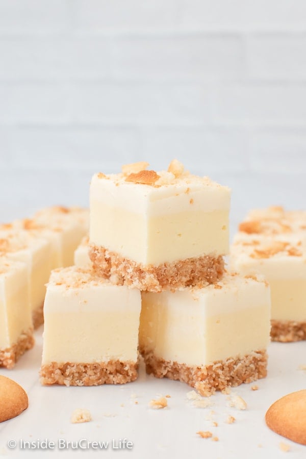 Three squares of banana fudge with a crust stacked on top of each other.