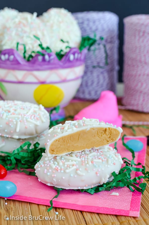 A white chocolate cookie butter egg on a pink napkin with another half of an egg stacked on top showing the filling