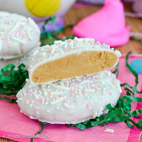 A white chocolate cookie butter egg on a pink napkin with another Biscoff egg half stacked on top of it.