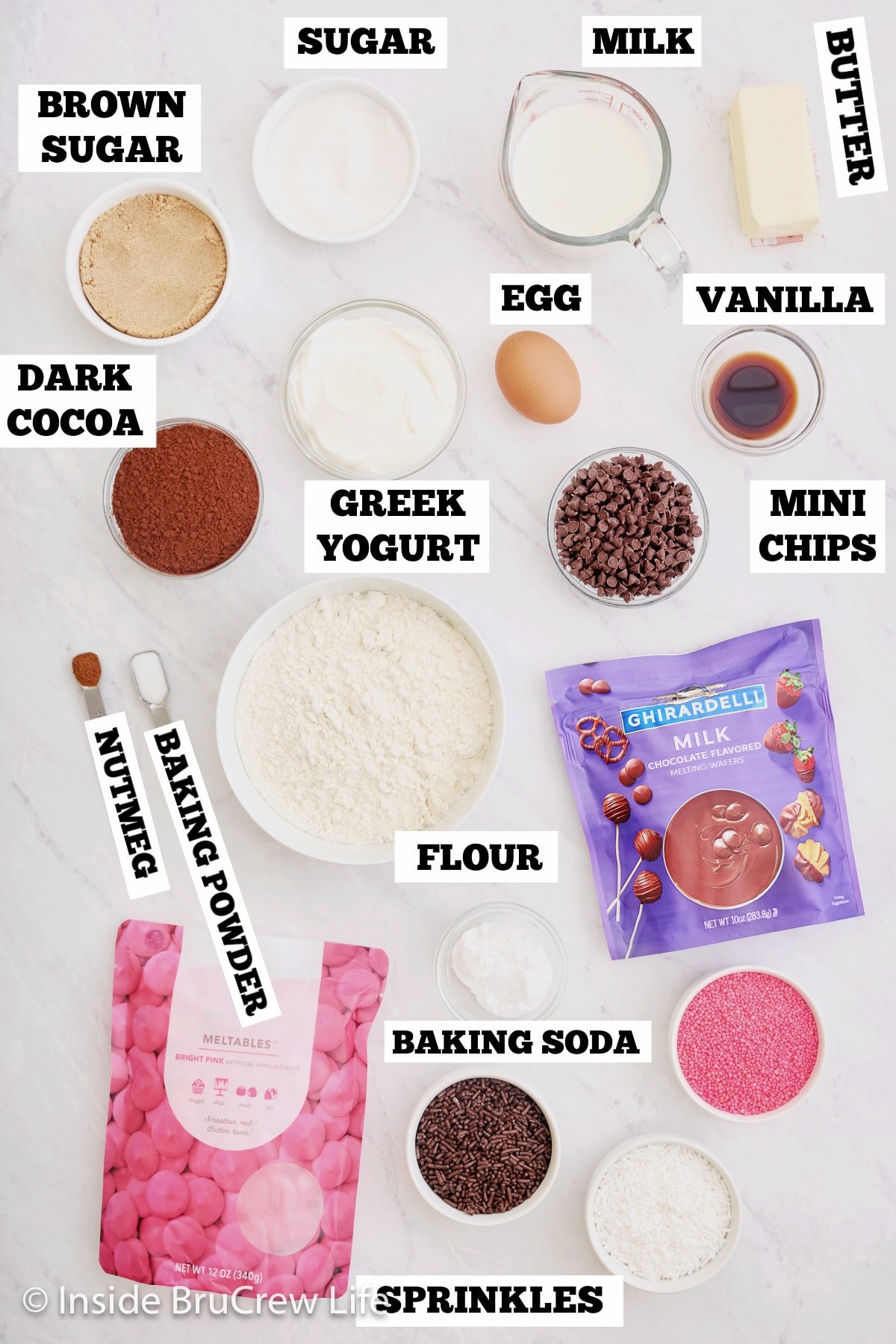 A white board with bowls of ingredients needed to make donuts.