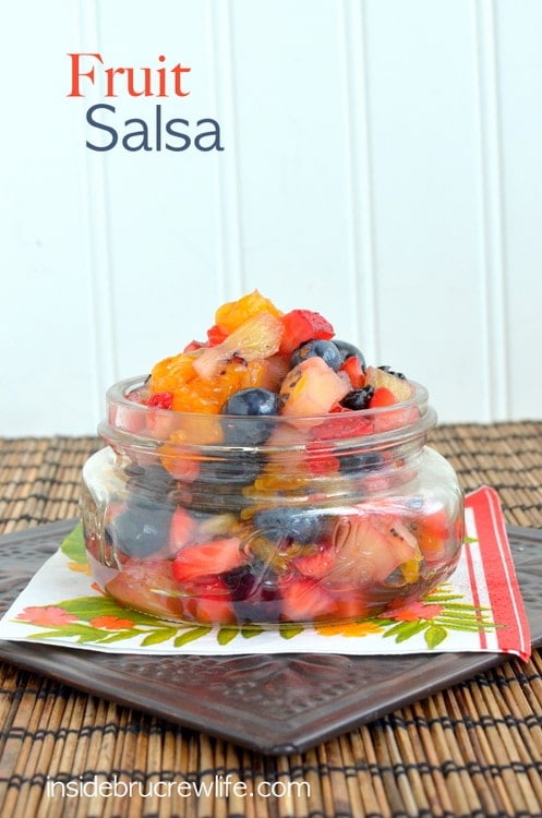 A jar of cut up fruit on a brown placemat