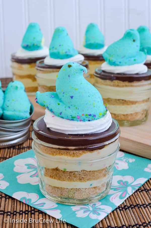 Close up picture of a blue peep sitting on a jar of eclair cake pudding with more jars in the background