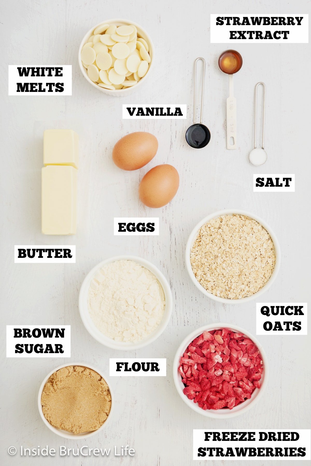 A white board with bowls of ingredients needed to make baked breakfast bars.