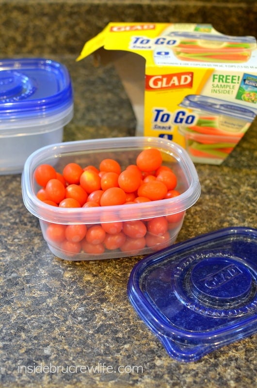 A clear plastic container filled with cherry tomatoes