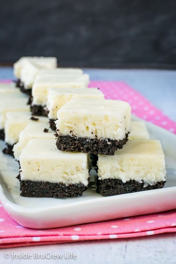 Multiple pieces of white coconut fudge with an oreo cookie base on a white plate.