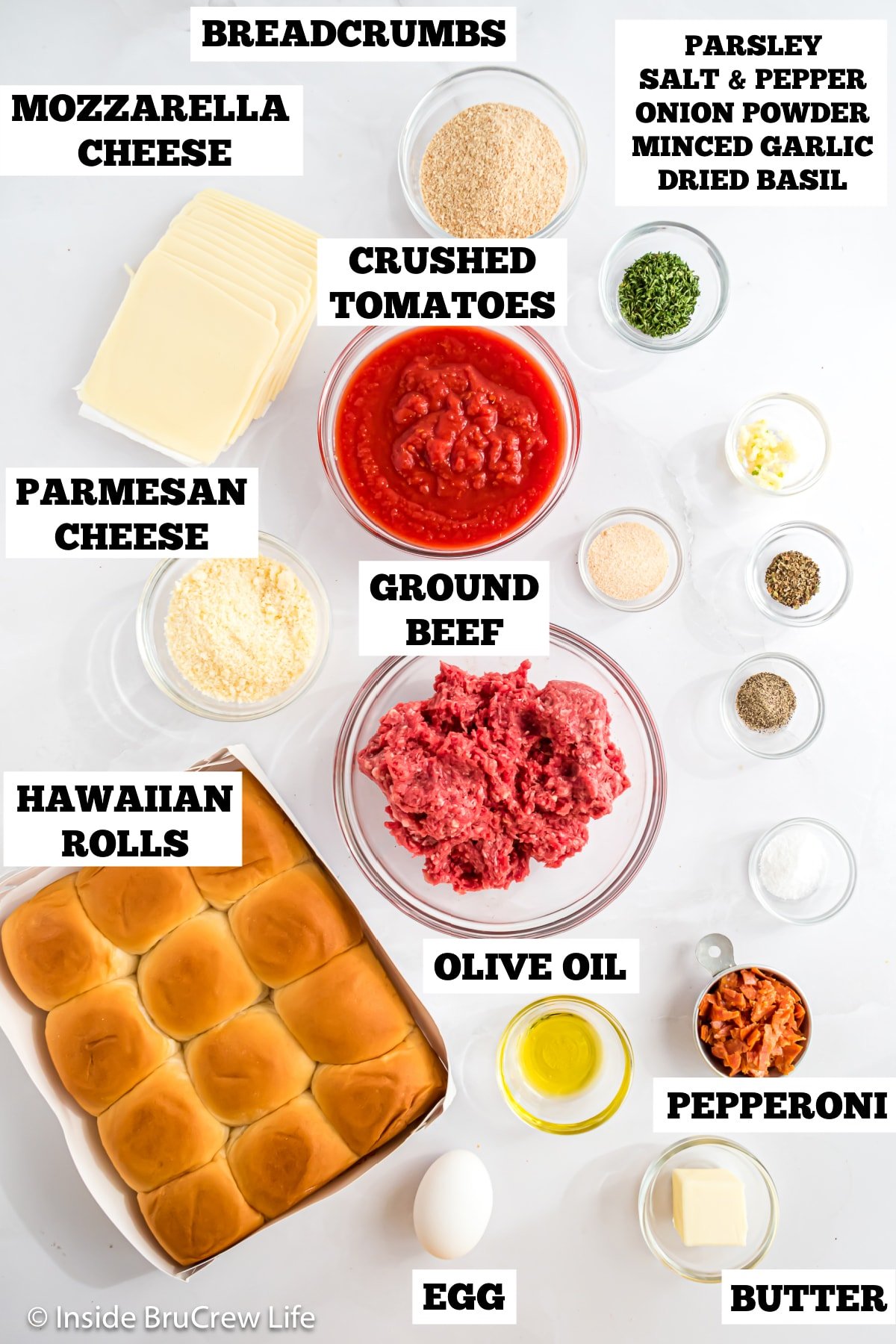 A white board with bowls of ingredients for homemade sliders.