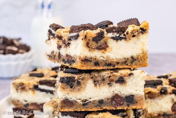 A stack of chocolate chip cheesecake bars with Oreos on a white plate.