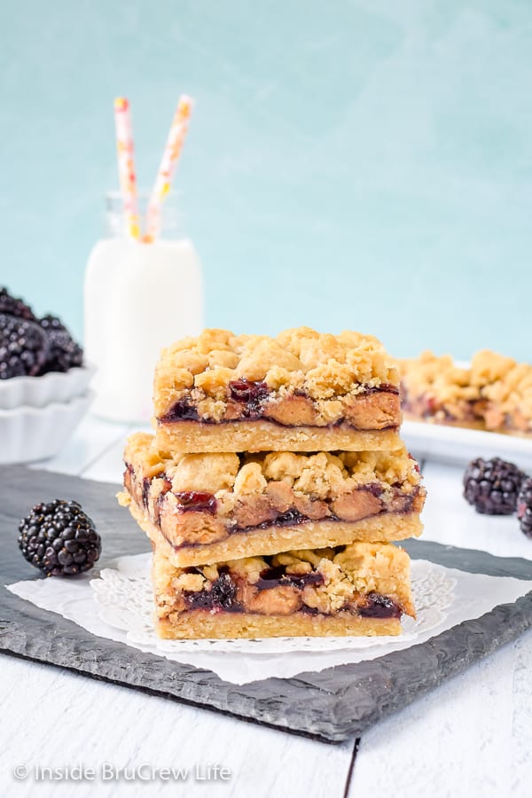 Peanut Butter and Jelly Crumb Bars - these sweet peanut butter and jelly bars are full of peanut butter cups and blackberry preserves. Easy dessert recipe! #peanutbutterandjelly #cookiebars #peanutbuttercups #blackberry #backtoschool