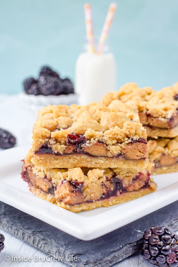 Peanut Butter and Jelly Crumb Bars - peanut butter cups and blackberry preserves give these easy crumble bars a fun peanut butter and jelly twist! Easy recipe for dessert or after school snacks. #peanutbutterandjelly #cookiebars #peanutbuttercups #blackberry #backtoschool