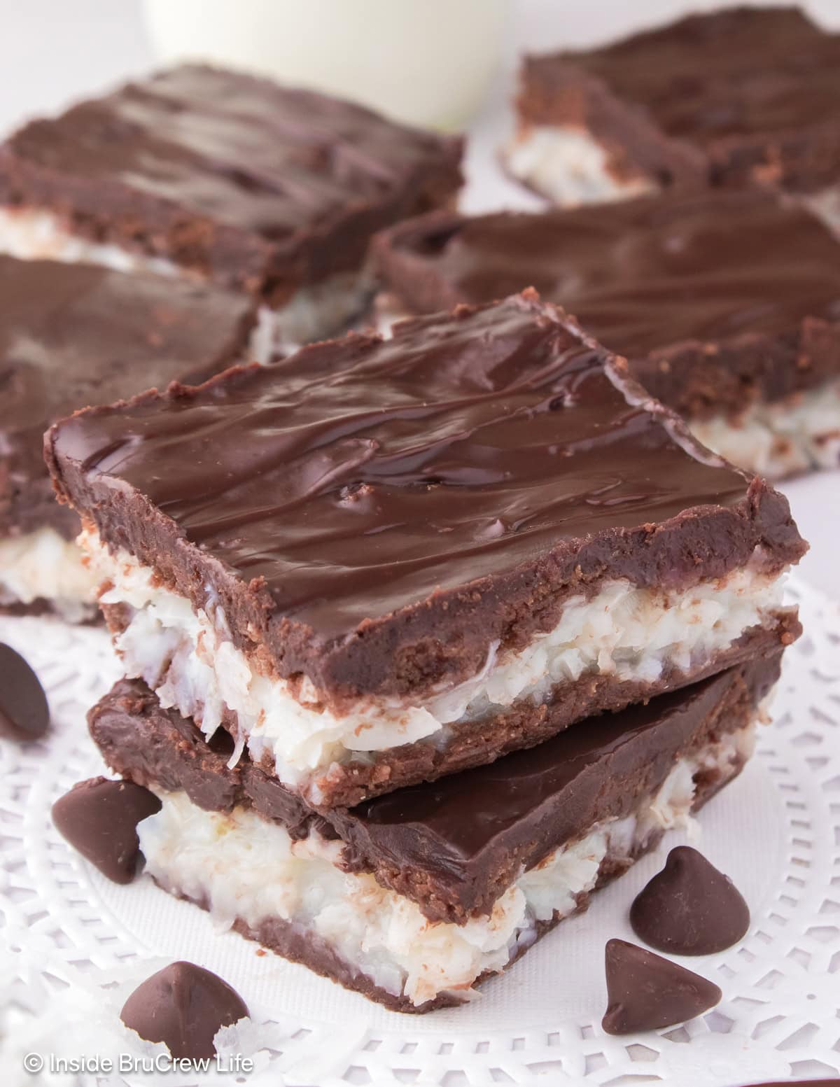 Chocolate and coconut bars stacked on a white board.