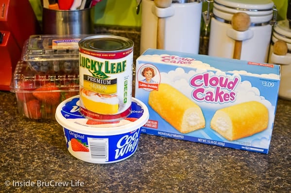 Ingredients to make a Lemon Fruit Parfait on a dark counter