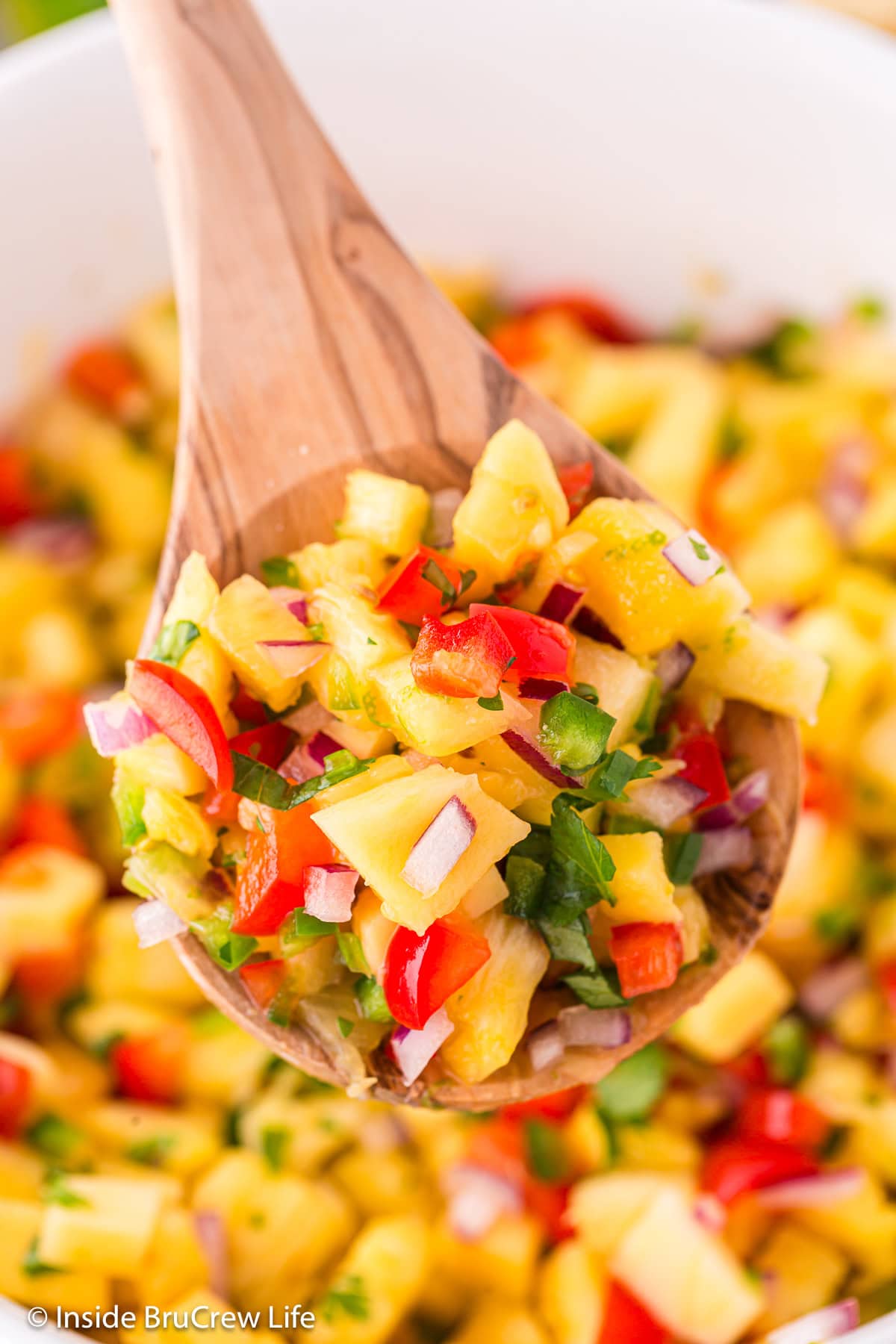 Fresh fruit salsa being served on a spoon.