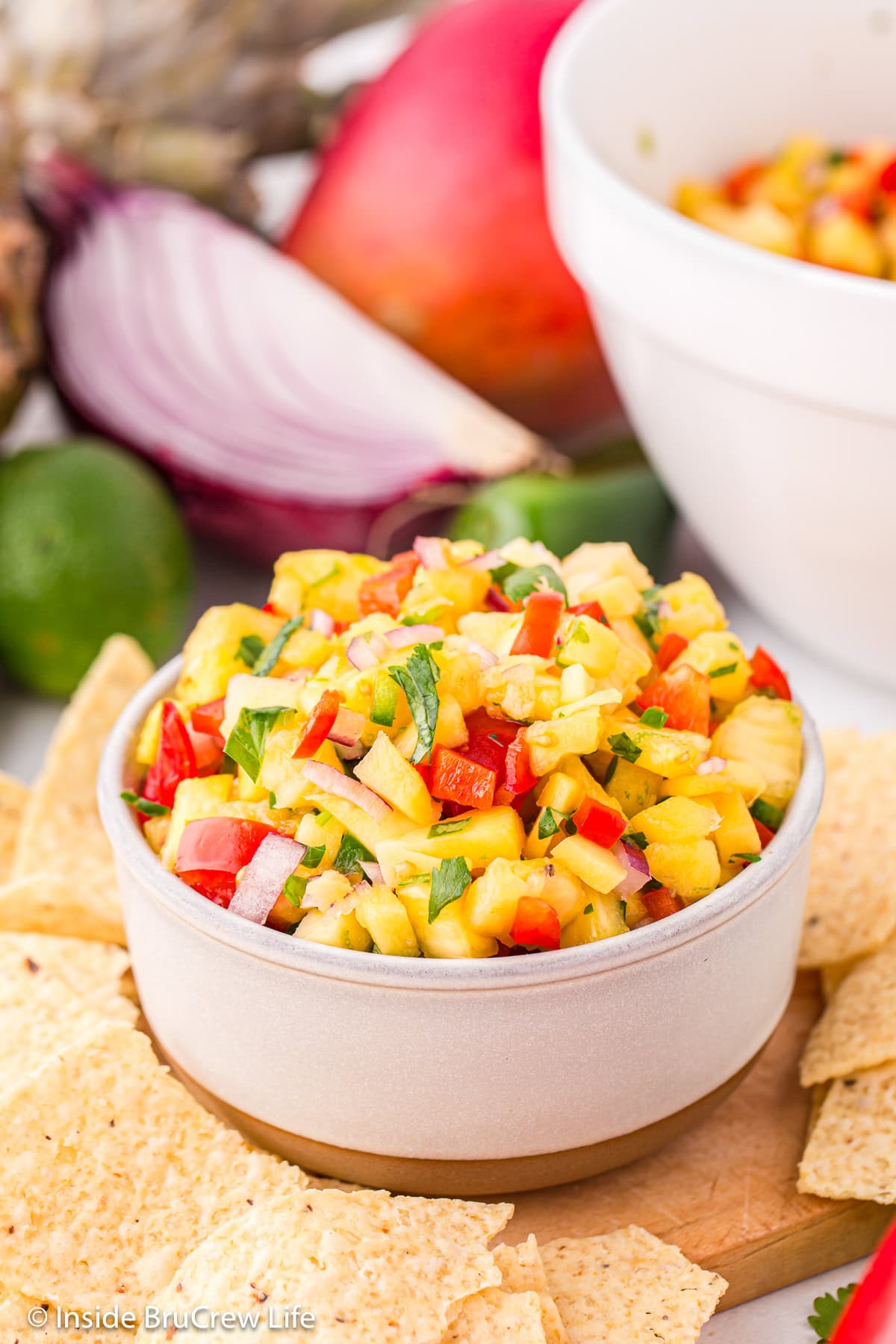 A white bowl filled with a pineapple mango salsa.