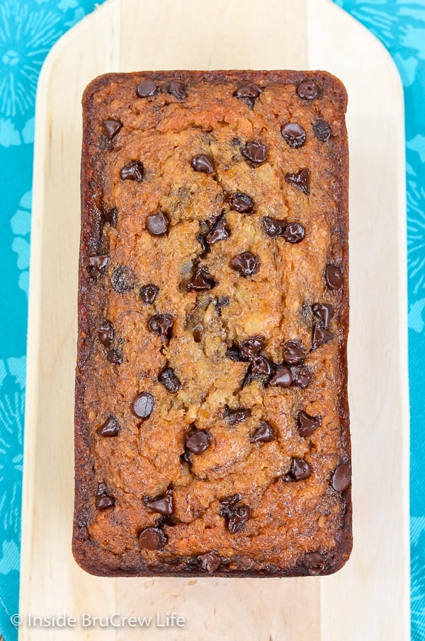 Overhead picture of a loaf of vegan banana bread with chocolate chips on a cutting board.