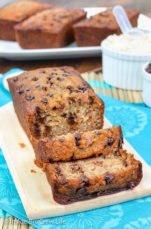 A loaf of healthy skinny banana bread on a cutting board with a few slices falling down in front.