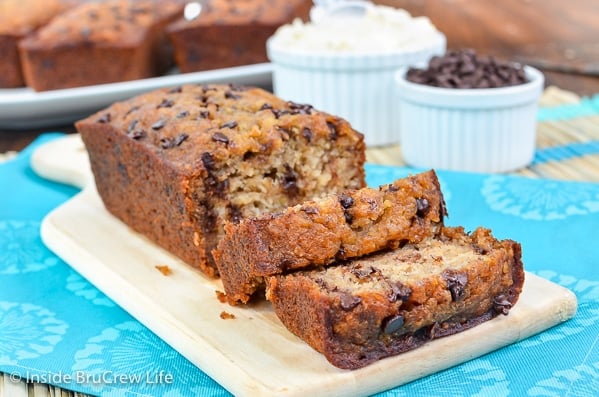 A loaf of oat flour banana bread on a cutting board with a a few slices falling down in front.