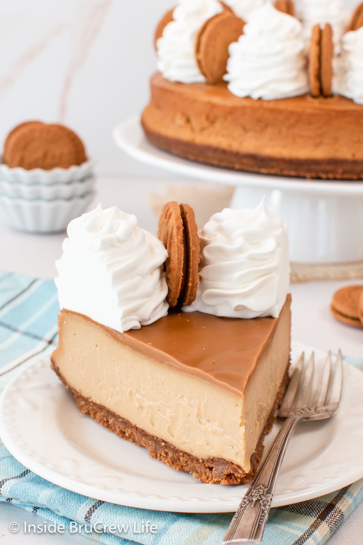 A slice of cookie butter cheesecake on a white plate.