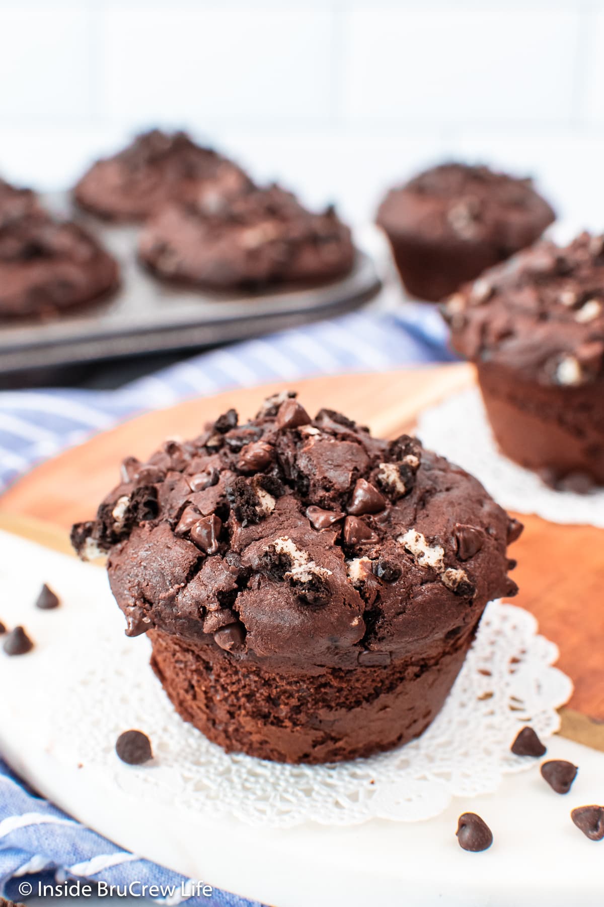 A dark chocolate muffin with cookies baked in it.