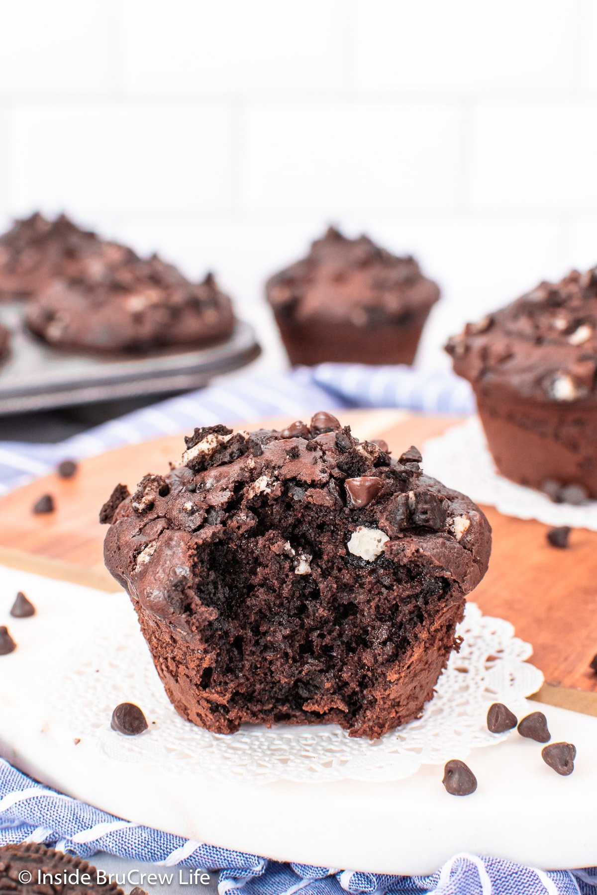 A chocolate cookie muffin with a bite out of it.