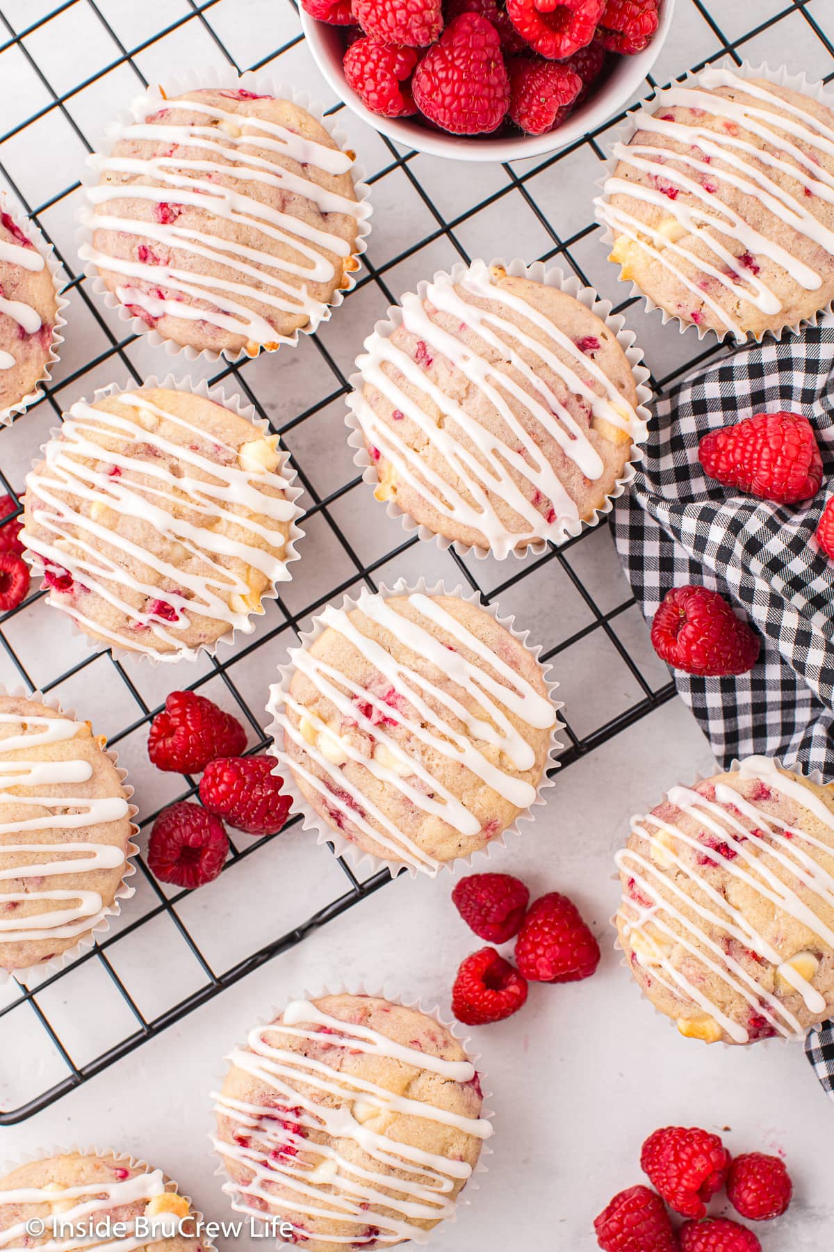 Glazed raspberry muffins on a cooling rack.