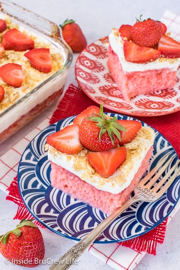 Overhead picture of two plates with strawberry cheesecake poke cake on them.