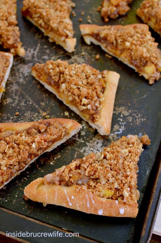 Apple Biscoff Crumble Pizza - pizza crust topped with Biscoff spread, apples, and a crumble topping with oats and Biscoff cookies https://insidebrucrewlife.com