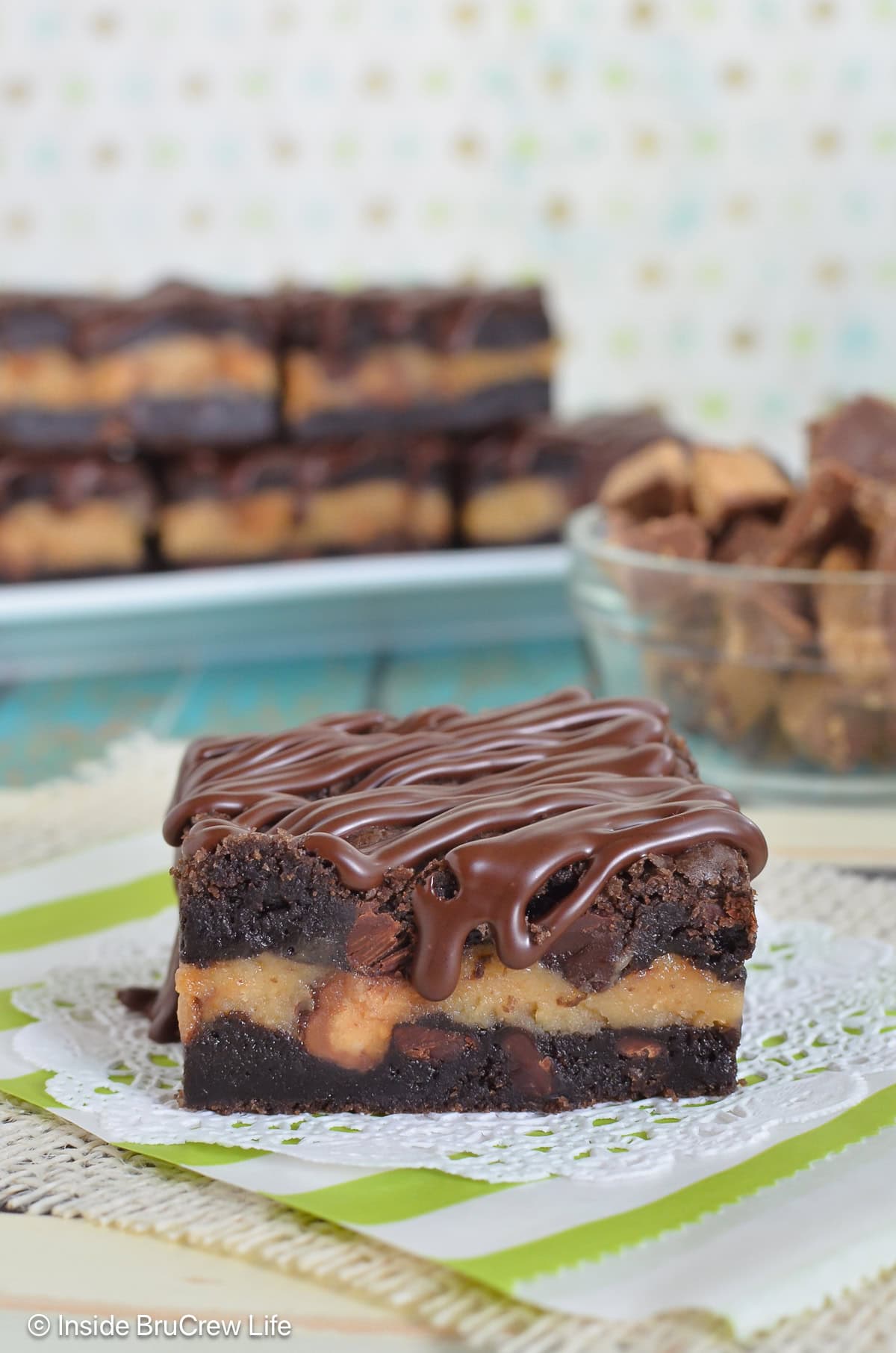 A chocolate cookie bar with chocolate drizzles on a white paper.