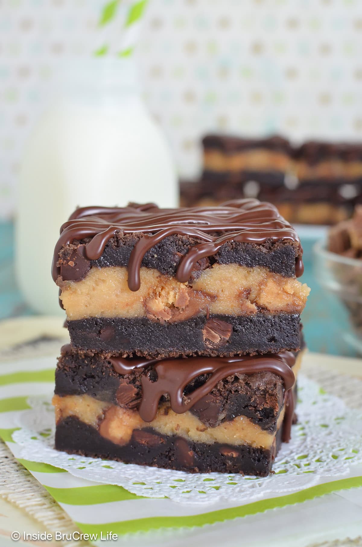 Two chocolate peanut butter cheesecake bars stacked on top of each other.