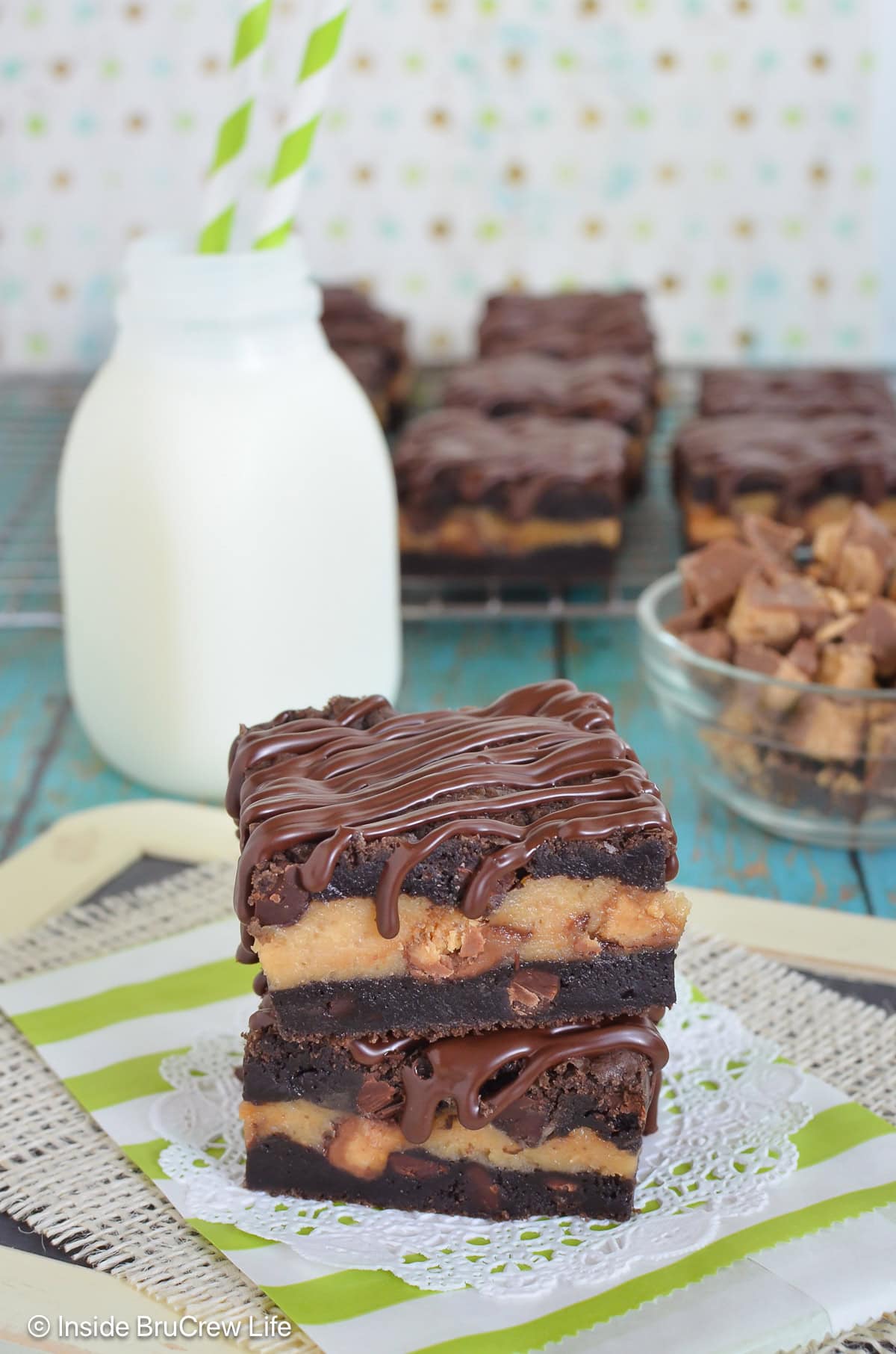 Cheesecake cookie bar squares stacked on top of each other.