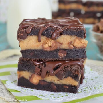 Two chocolate peanut butter cheesecake bars stacked on top of each other.