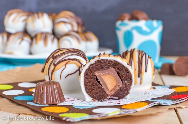 A chocolate cookie dough truffle cut in half showing the hidden peanut butter cup candy inside.