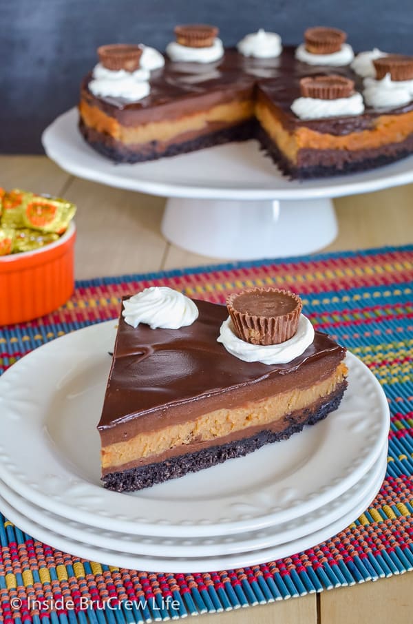 Peanut Butter Cup Cheesecake - layers of chocolate and peanut butter cheesecake with an Oreo crust. Make this recipe for dinner parties and watch it disappear! #cheesecake #peanutbutter #chocolate #peanutbuttercups