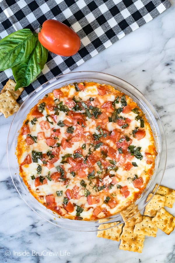 Overhead picture of a cheesy tomato dip with crackers.