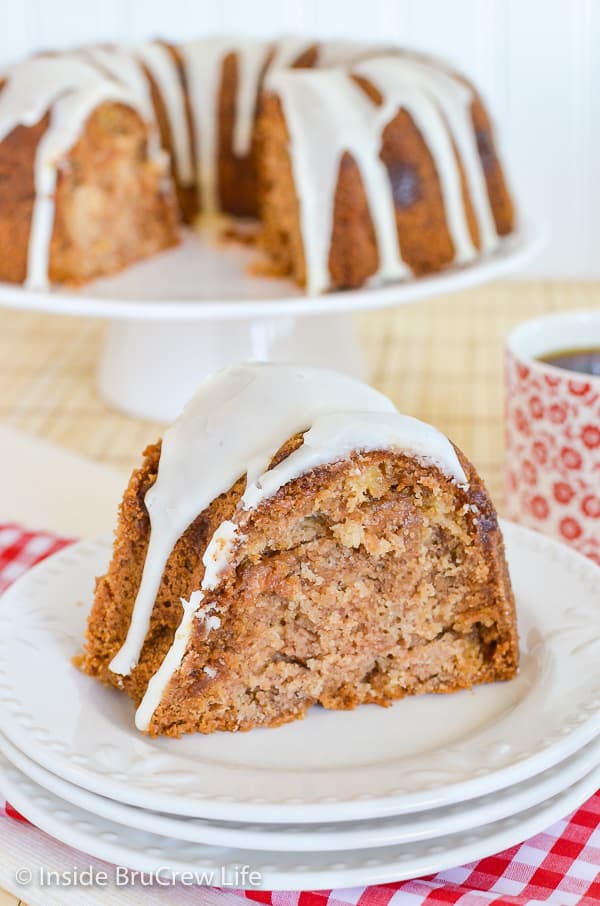 A slice of glazed apple bundt cake on a white plate.