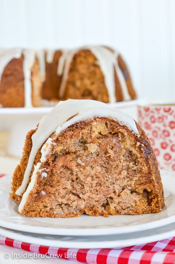 A slice of apple bundt cake with apple cider glaze on a white plate.