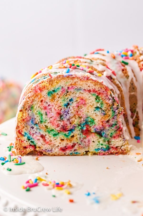 A close up of the inside of a bundt cake loaded with rainbow sprinkles.