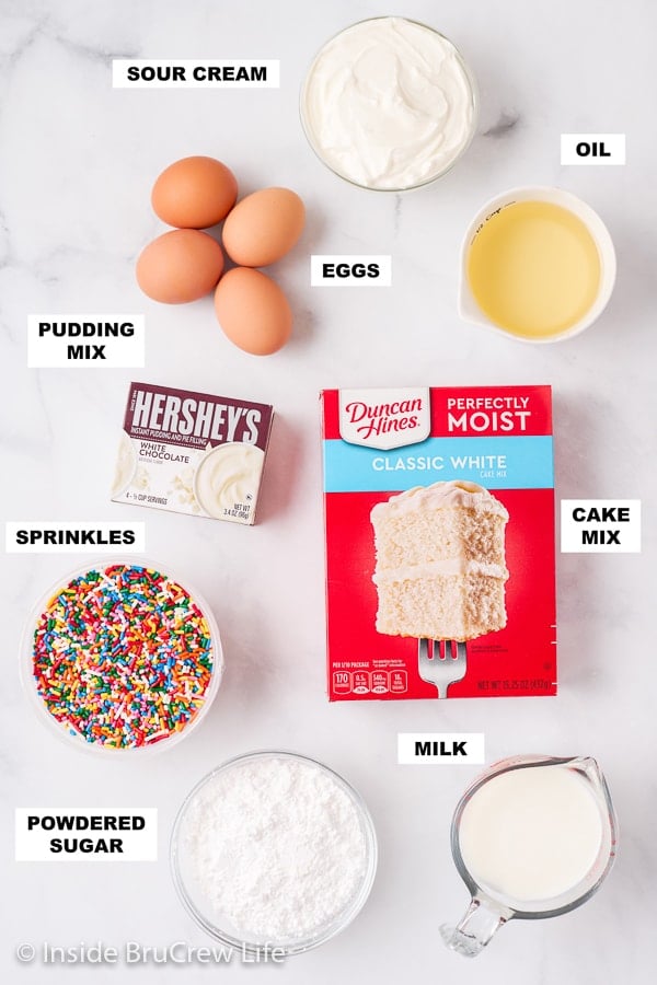 A white board with bowls of ingredients needed to make a bundt cake recipe.