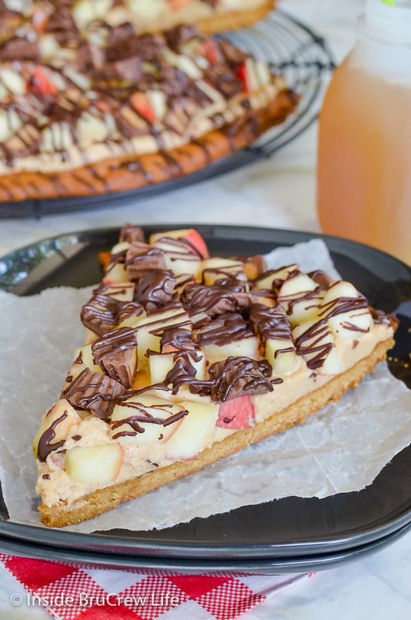 Peanut Butter Apple Pizza - this easy cookie pizza is loaded with a creamy peanut butter topping, apples, and peanut butter cups. Try this easy recipe for fall parties! #peanutbutter #apple #cookiepizza #fall #cookie #peanutbuttercups