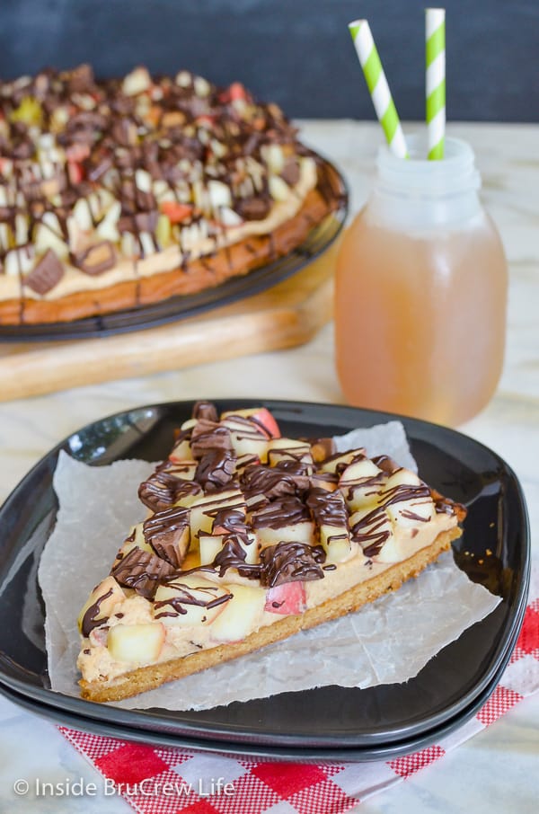 Peanut Butter Apple Pizza - apples and peanut butter cups on top of a peanut butter cookie pizza makes a great dessert! Make this easy recipe for parties! #peanutbutter #apple #cookiepizza #fall #cookie #peanutbuttercups