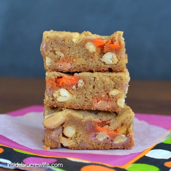 Peanut Butter Candy Corn Blonde Brownies - peanuts, candy corn, and Reese's pieces inside a peanut butter blonde brownie www.insidebrucrewlife.com
