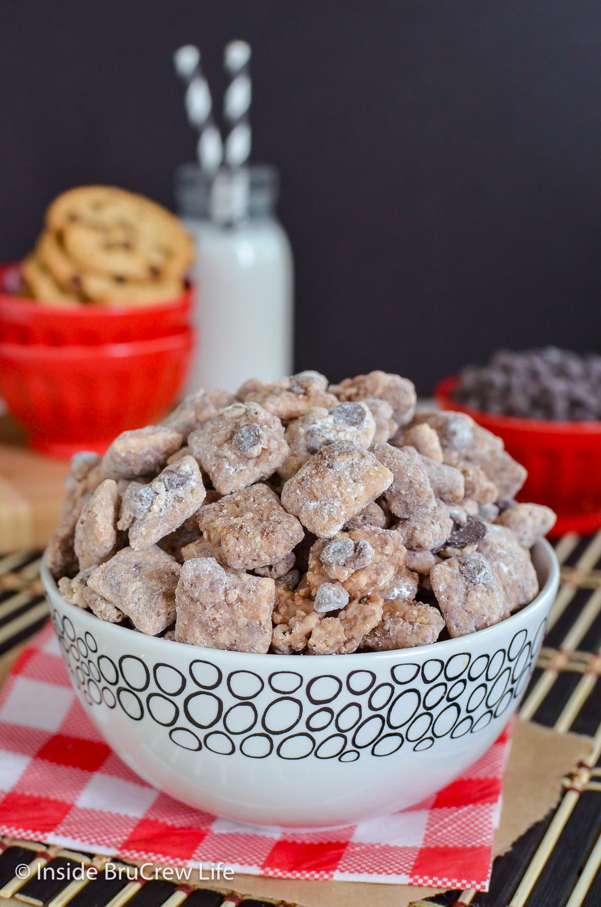 Chocolate muddy buddies in a white bowl.