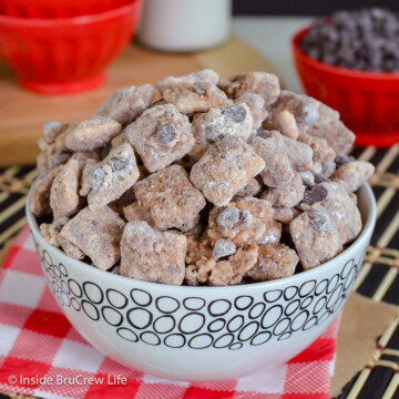 A white bowl of muddy buddies with chocolate chips.