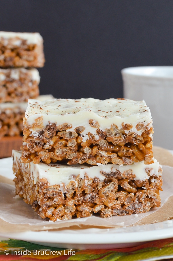 Two pumpkin spice treats topped with white chocolate stacked on a white plate.