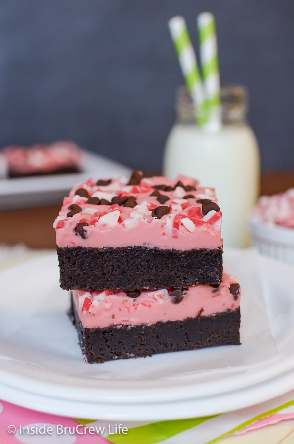 Two peppermint chip brownies covered with pink frosting.