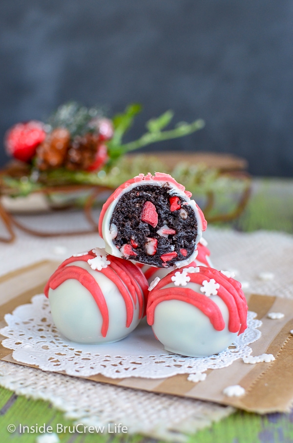 Three peppermint Oreo truffles stacked on a white doily with the top one cut in half