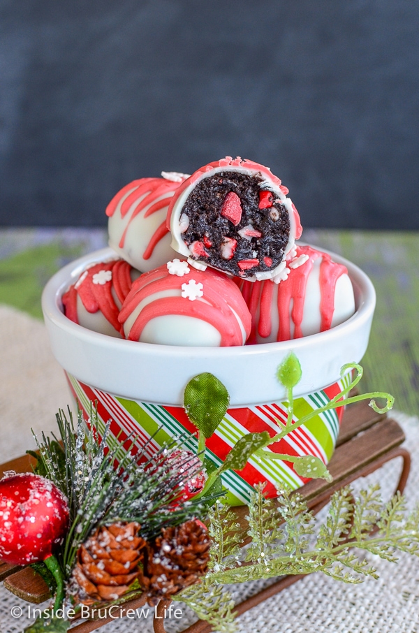 A holiday bowl filled with peppermint crunch Oreo truffles sitting on a Christmas sled